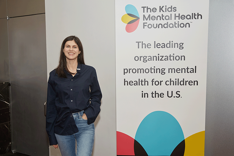 Alexandra Daddario standing with Kids Mental Health Foundation sign