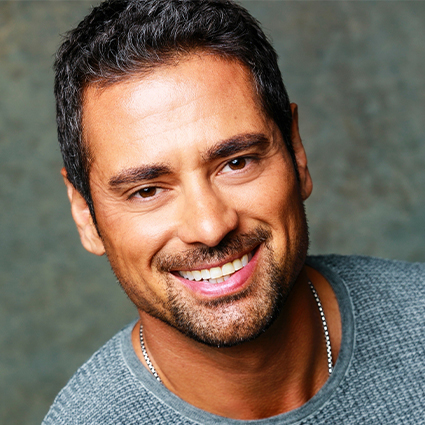 Headshot of actor J.R. Ramirez smiling at the camera.