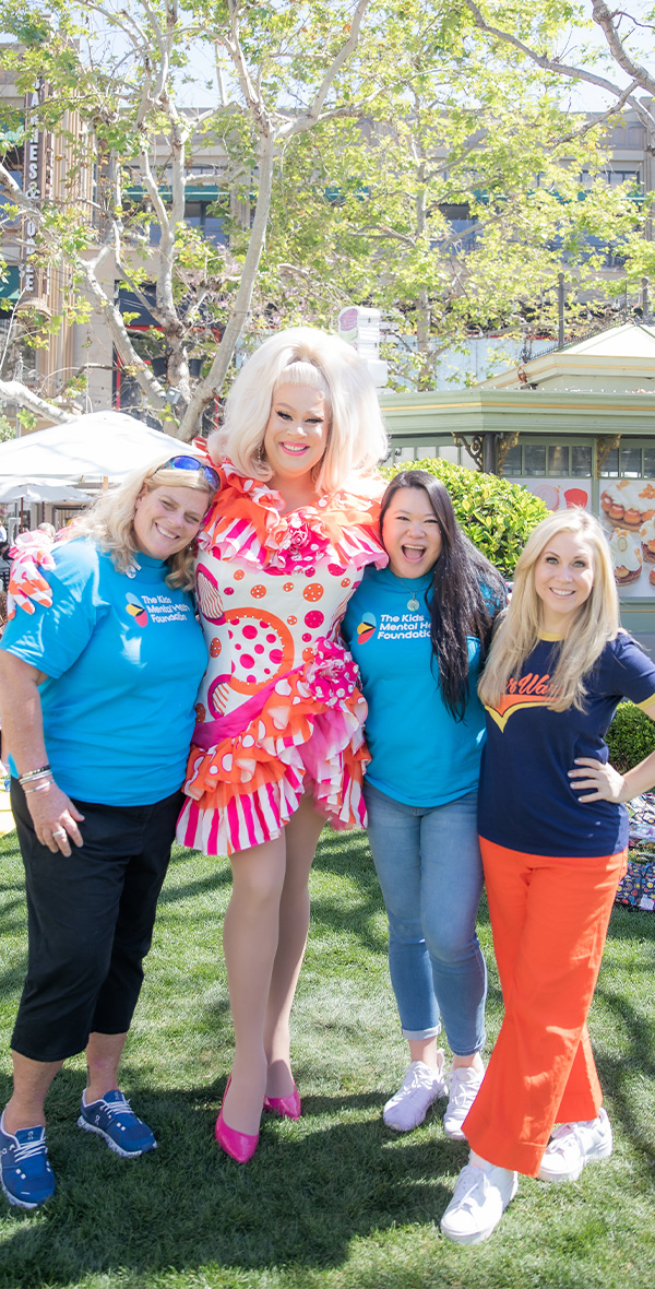 Andrew Levitt, known professionally as Nina West, poses with Kids Mental Health Foundation supporters at a community event promoting children’s mental health.