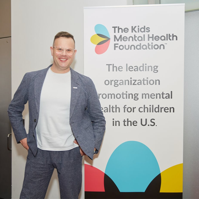 Andrew Levitt, known professionally as Nina West, poses with Kids Mental Health Foundation supporters at a community event promoting children’s mental health.