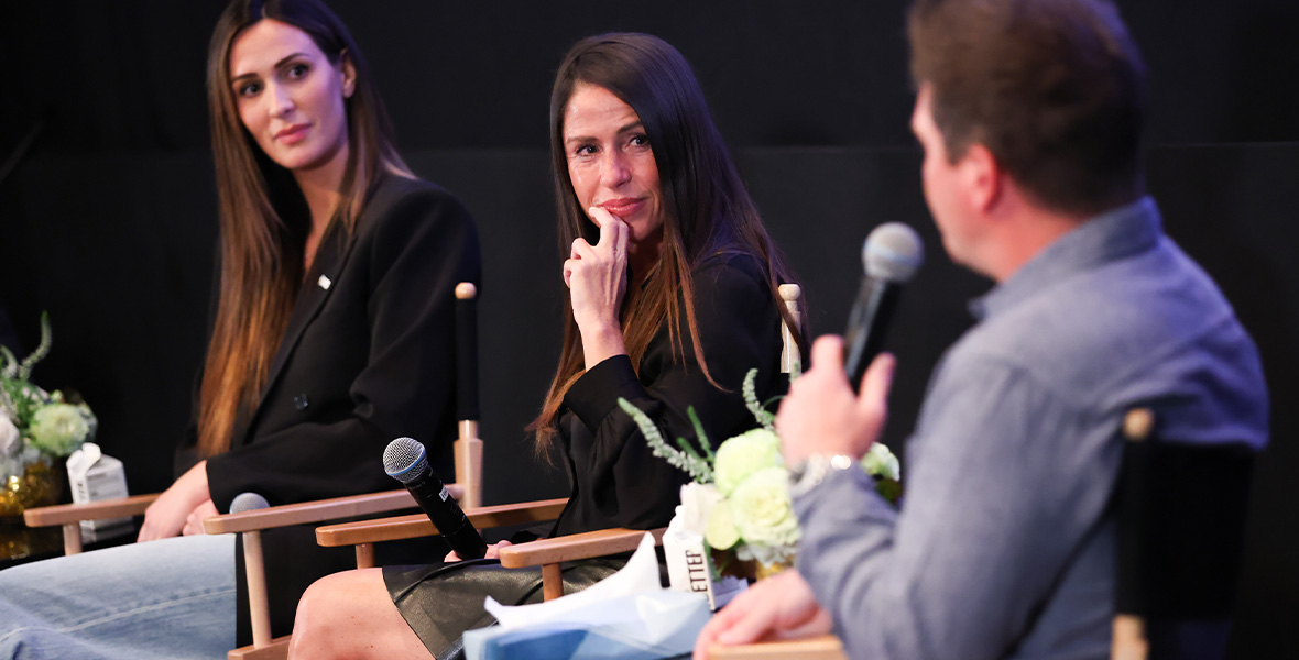 Soleil Moon Frye listens intently during a panel discussion on youth mental health, seated beside fellow advocate Angel Carter Conrad. Both appear engaged in the conversation, highlighting community support and awareness.