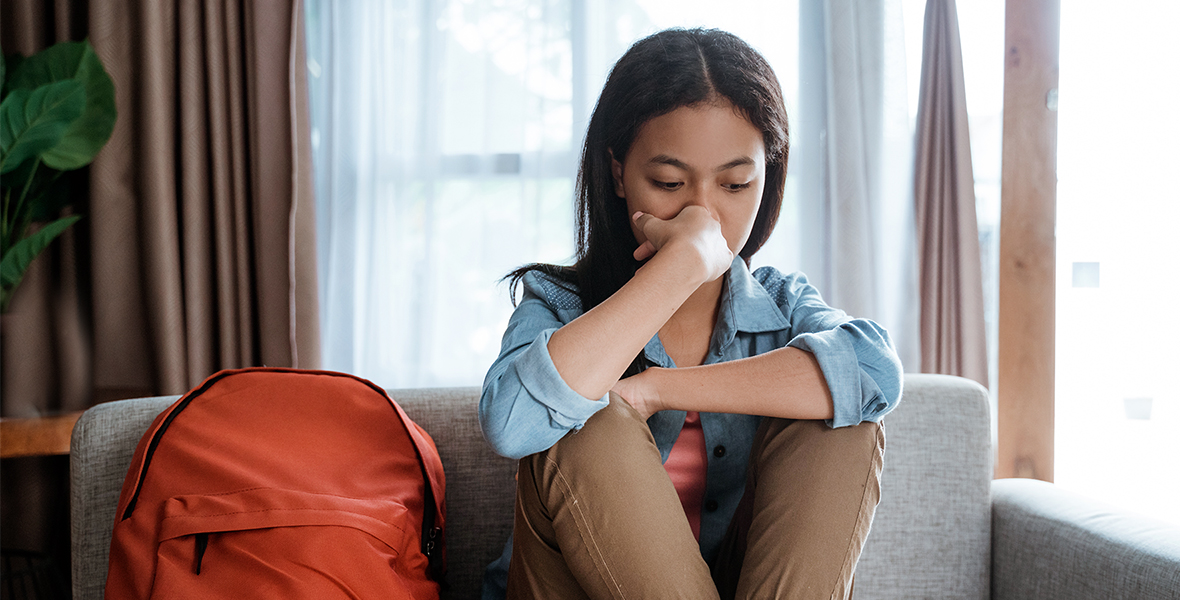Teen girl sitting alone with a worried expression, struggling with anxiety and emotional stress. Highlighting the importance of youth mental health support and early intervention.