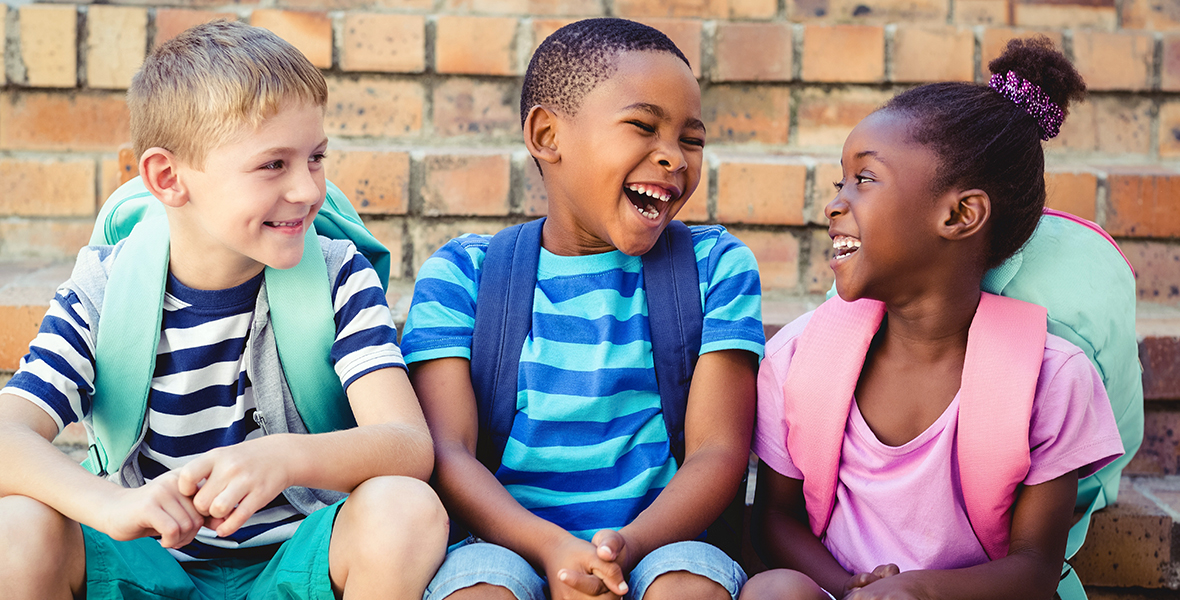 Diverse group of happy schoolchildren laughing together, building strong friendships and social connections. Positive peer relationships supporting children's mental health and emotional well-being.