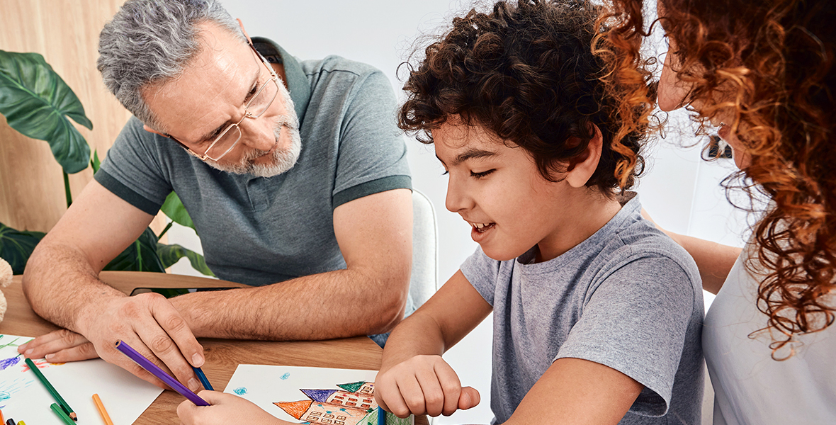 Happy child engaging in art therapy with supportive adults, fostering creativity and emotional expression. Encouraging open conversations about mental health through creative activities.