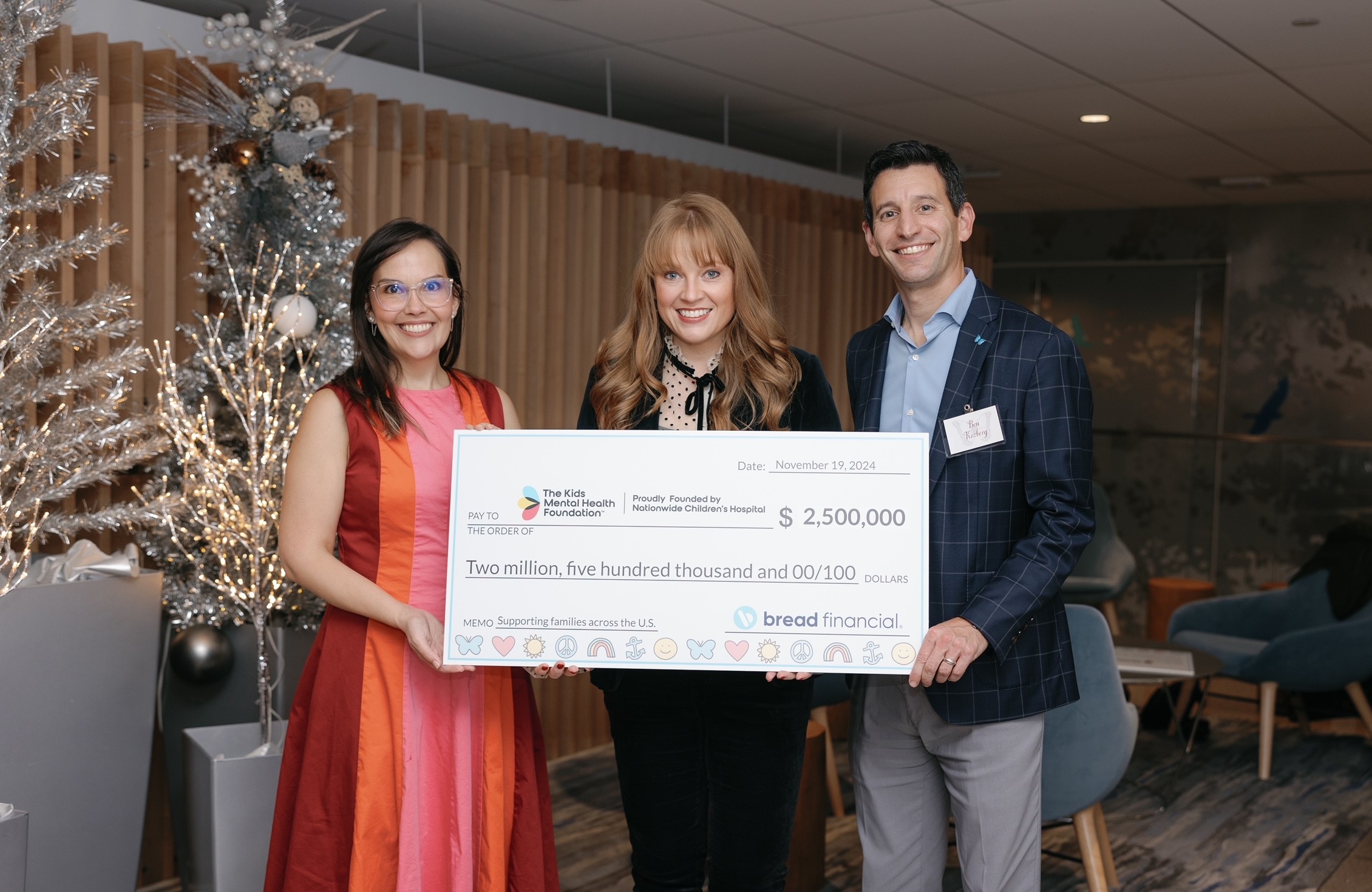 Representatives from Bread Financial present a $2.5 million donation check to The Kids Mental Health Foundation on November 19, 2024, in support of families across the U.S. Pictured in front of festive holiday decor.