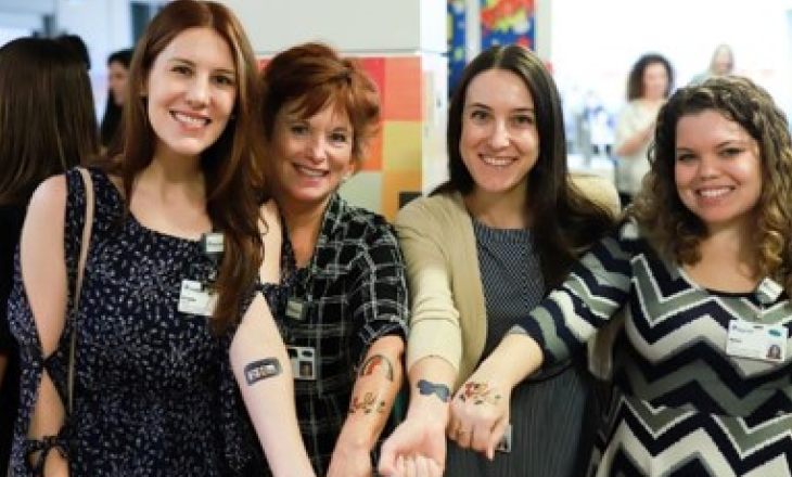 A group of women displaying temporary tattoos