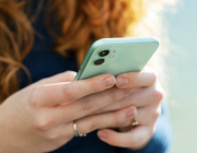 Hands holding a green iPhone