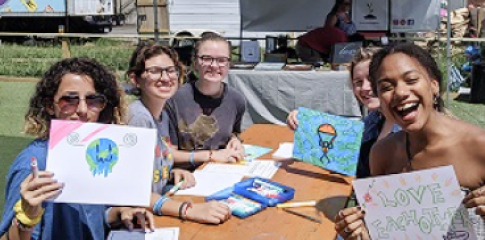 A group of people holding up drawing they made