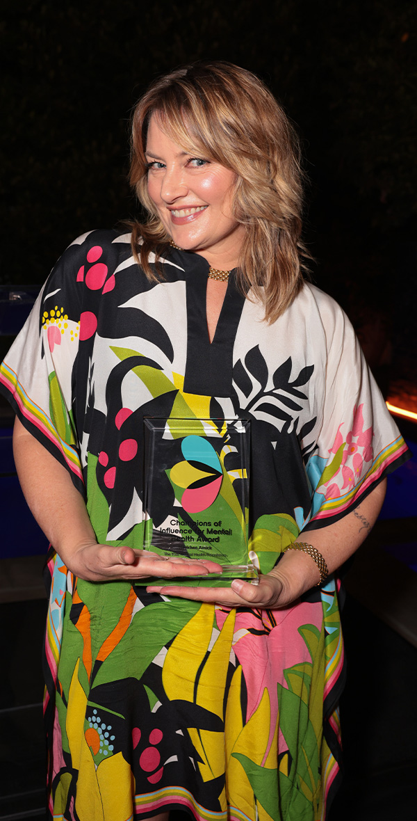 Mädchen Amick sonríe mientras sostiene su «Premio Champions of Influence for Mental Health» en un acto de la Kids Mental Health Foundation, en reconocimiento a su labor en defensa del bienestar mental de los niños.