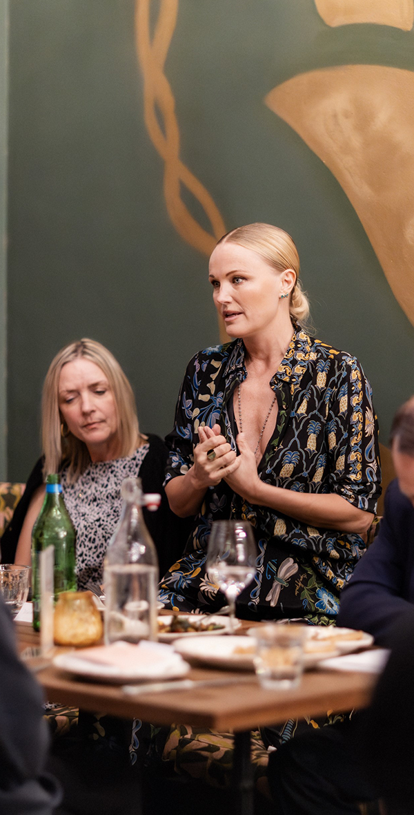 La actriz y defensora de la salud mental Malin Åkerman interviene en una mesa redonda organizada por The Kids Mental Health Foundation, sentada en el escenario junto a otros ponentes que promueven el bienestar emocional y el apoyo a los jóvenes.