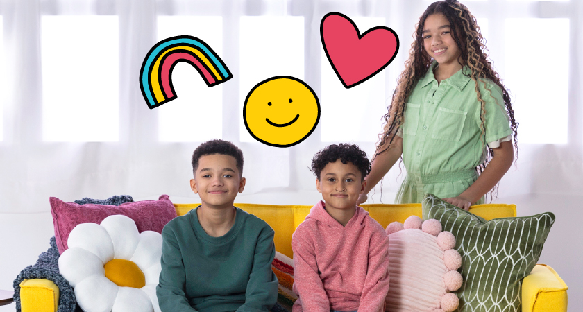 Kids sitting on couch with a rainbow, smiley face, and heart above them