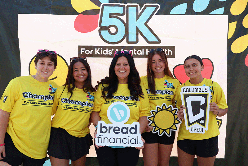 Un corredor cruza la línea de meta durante la carrera de 5 km «For Kids’ Mental Health», pasando junto a los carteles publicitarios de los socios del Columbus Crew, que apoyan la concienciación sobre la salud mental de los jóvenes.